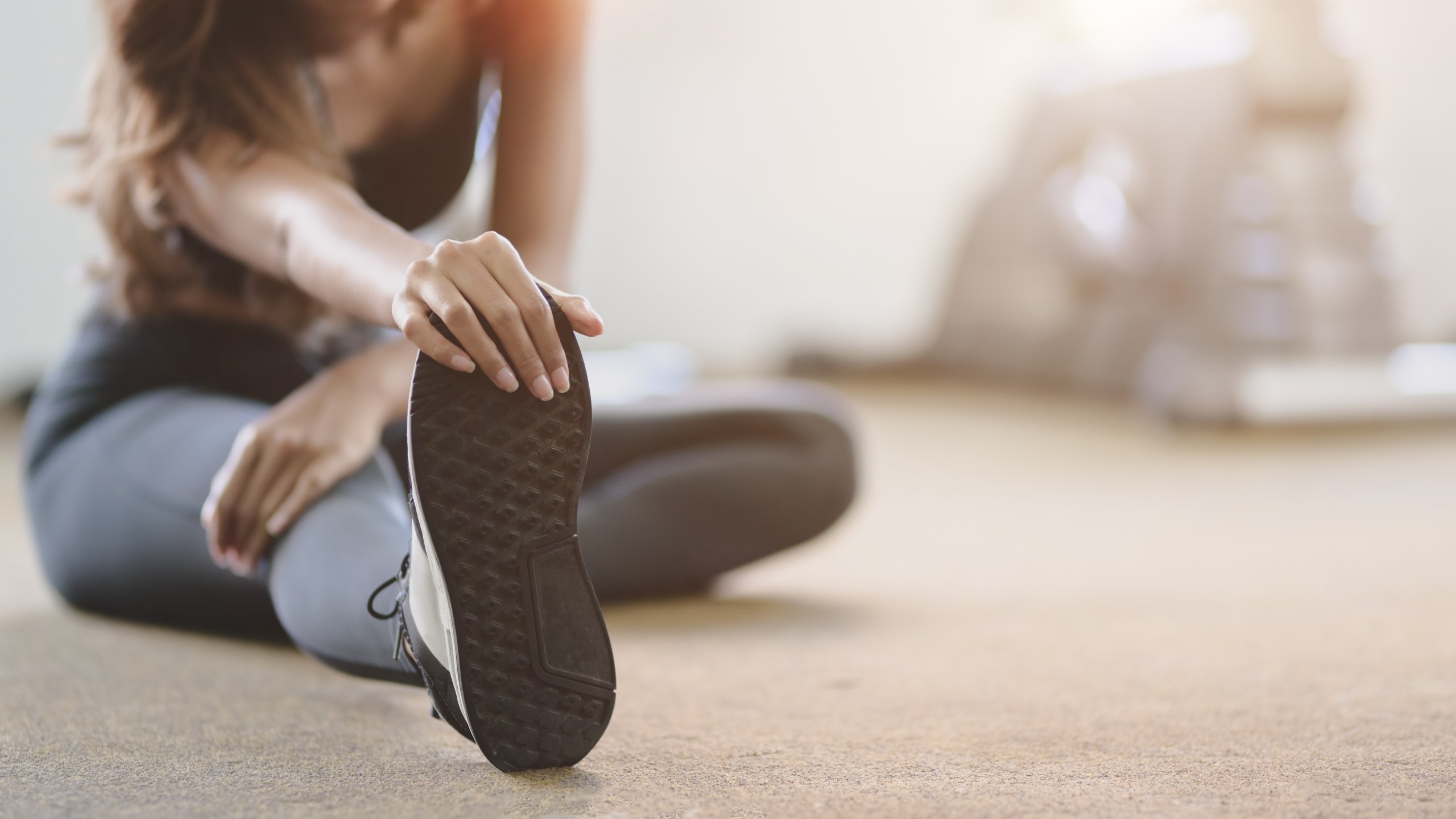 A woman stretching her legs before exercise at the gym